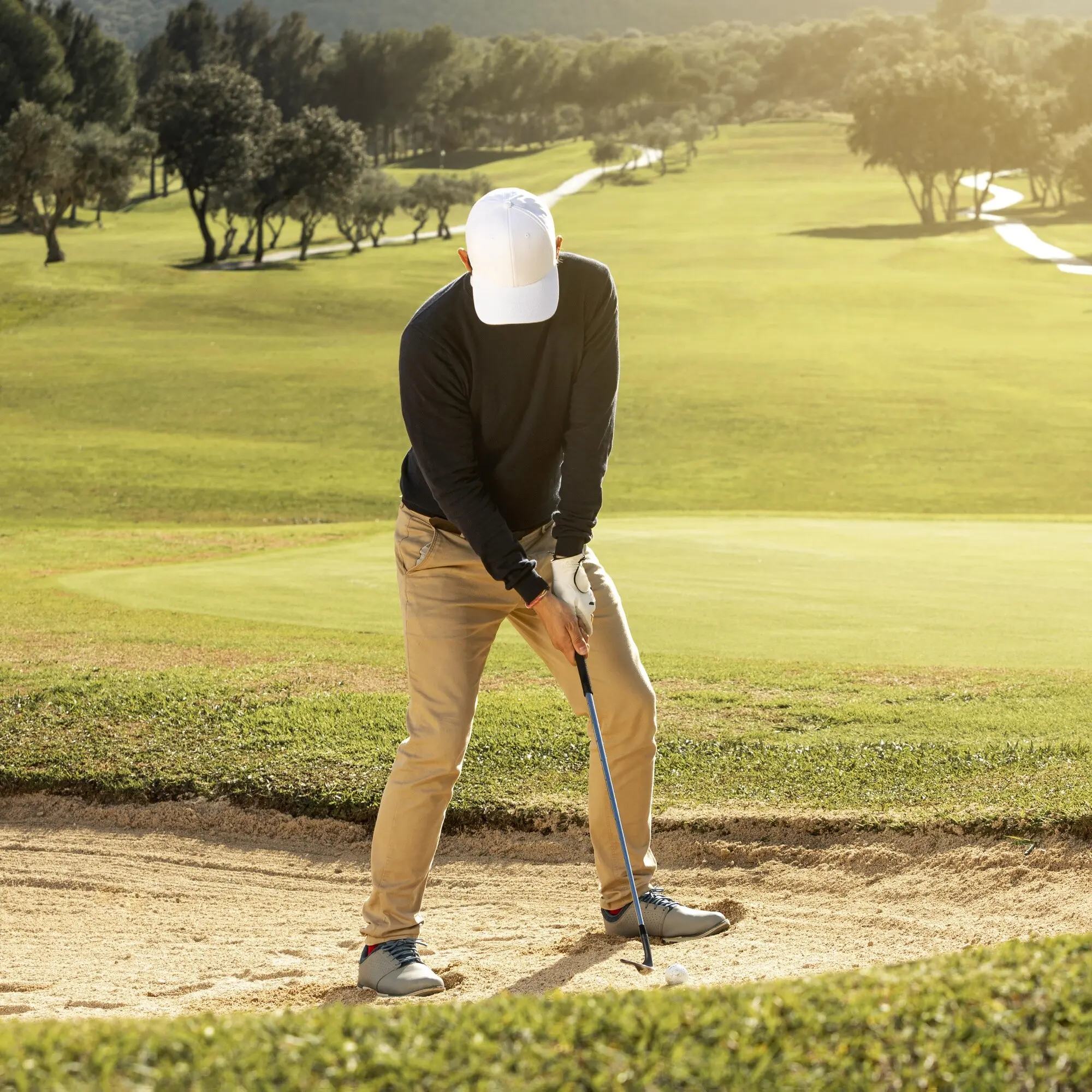 Vista frontal de un hombre jugando al golf con un palo.